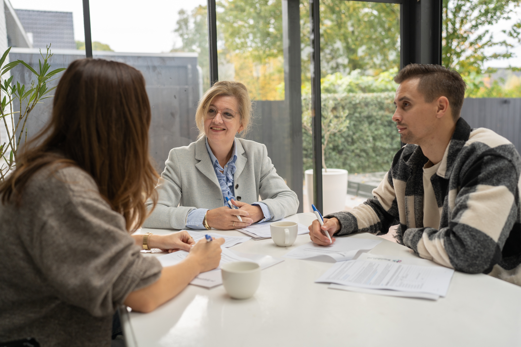 Stel en mediator die samen afspraken bespreken aan tafel