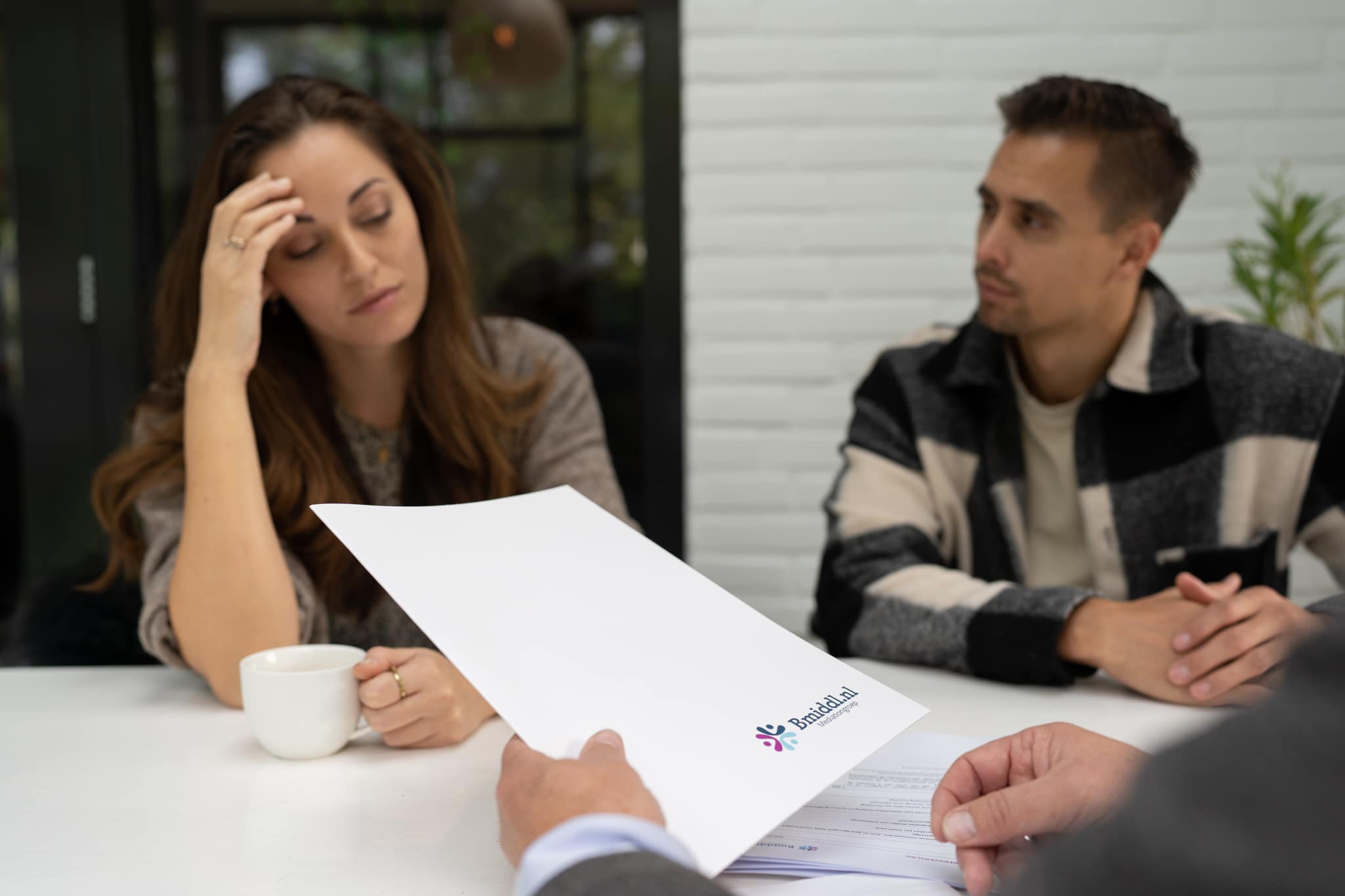 Twee mensen tijdens een mediation sessie bij Bmiddl. De Mediator houdt een papier vast.